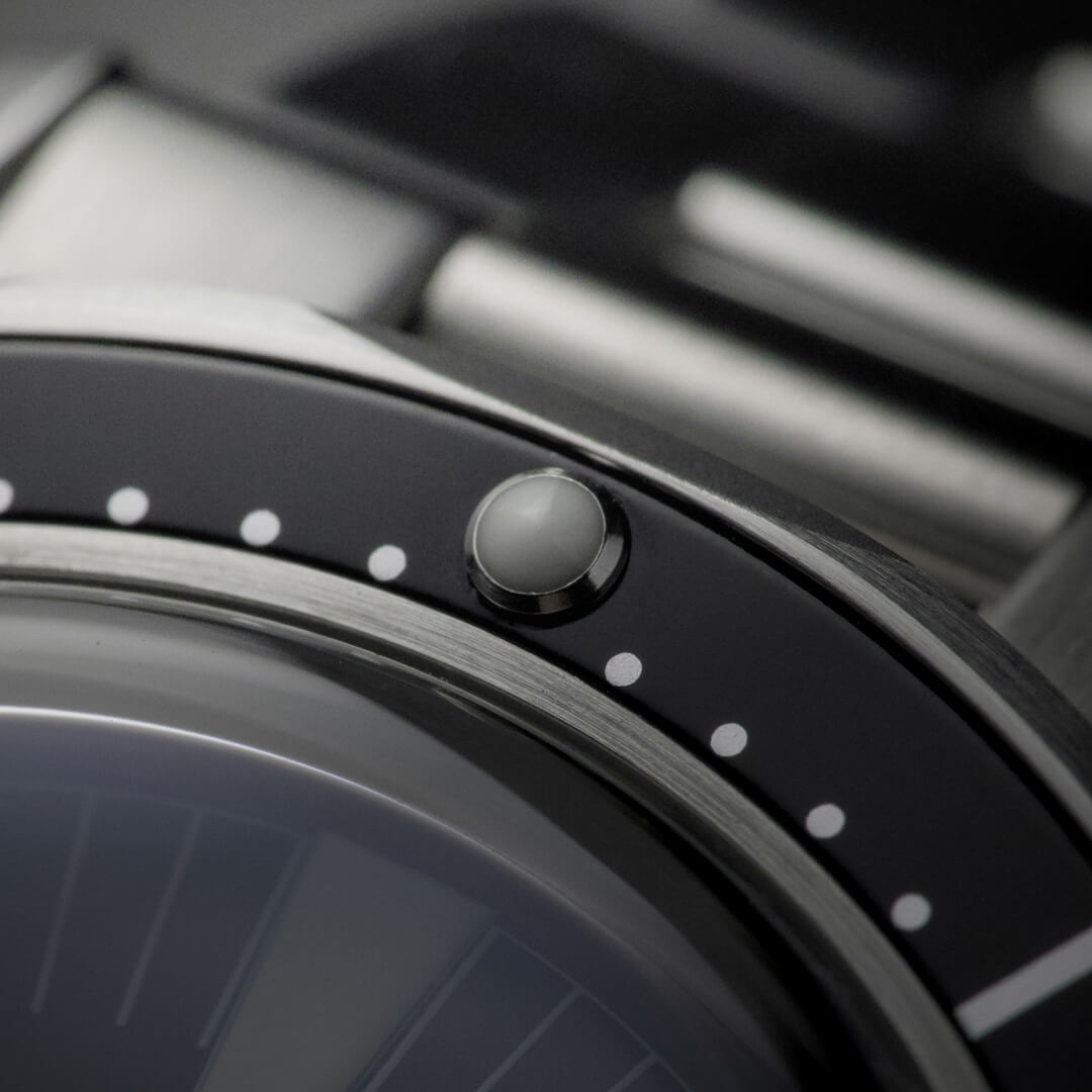 Dettaglio macro della ghiera girevole dell’orologio HTD Aquatic Spaceboy con punto luminoso a ore 12.