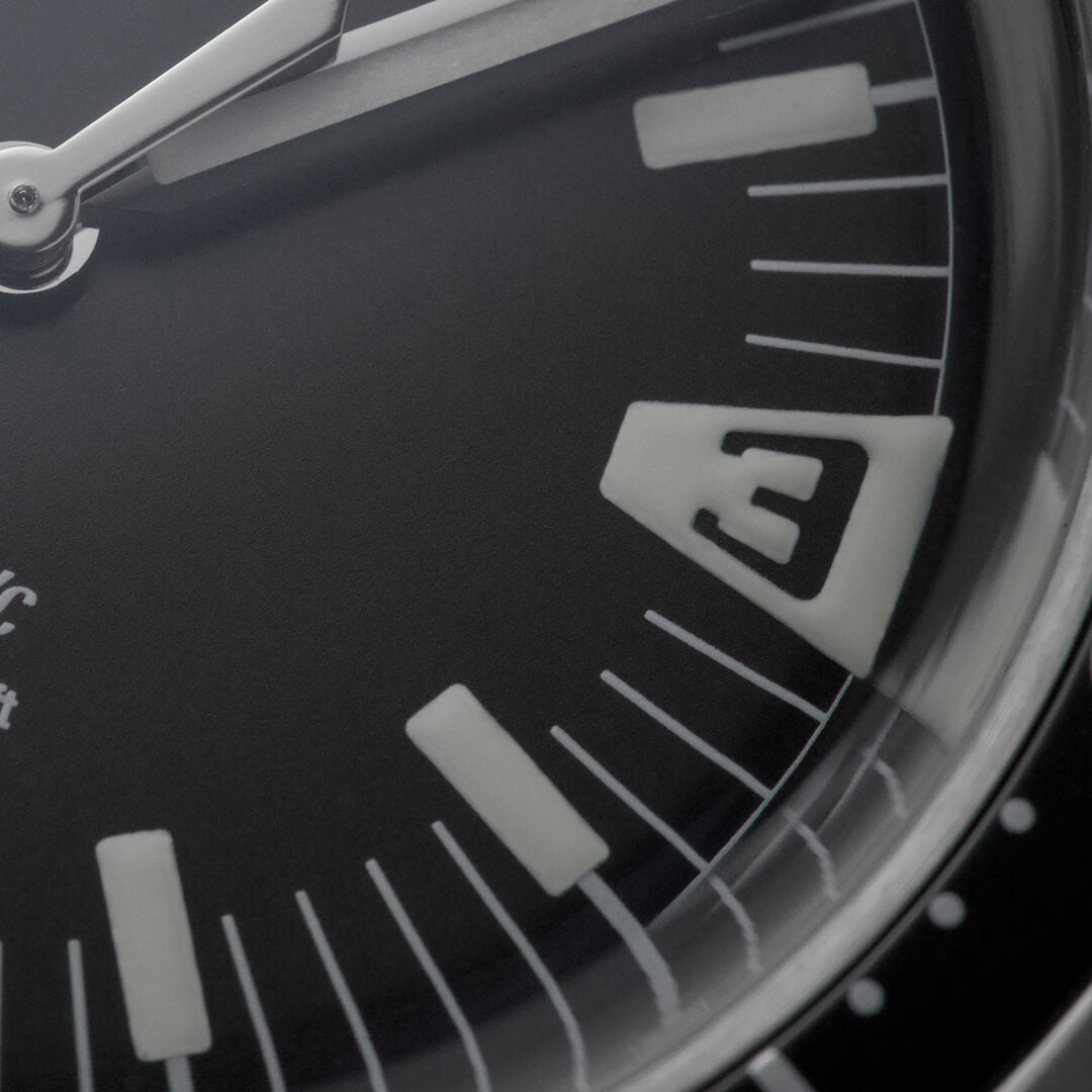 Macro del quadrante nero dell’orologio HTD Aquatic Spaceboy con indici luminescenti e numero 3 stilizzato.