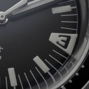 Macro del quadrante nero dell’orologio HTD Aquatic Spaceboy con indici luminescenti e numero 3 stilizzato.