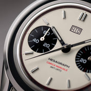 Macro del quadrante di un orologio cronografo HTD Hesagraph con quadrante crema e contatori neri a contrasto.