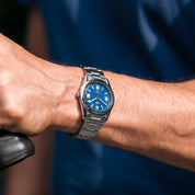 Orologio HTD Tennis Cemento indossato al polso con protezione in gomma nera applicata sul quadrante blu.