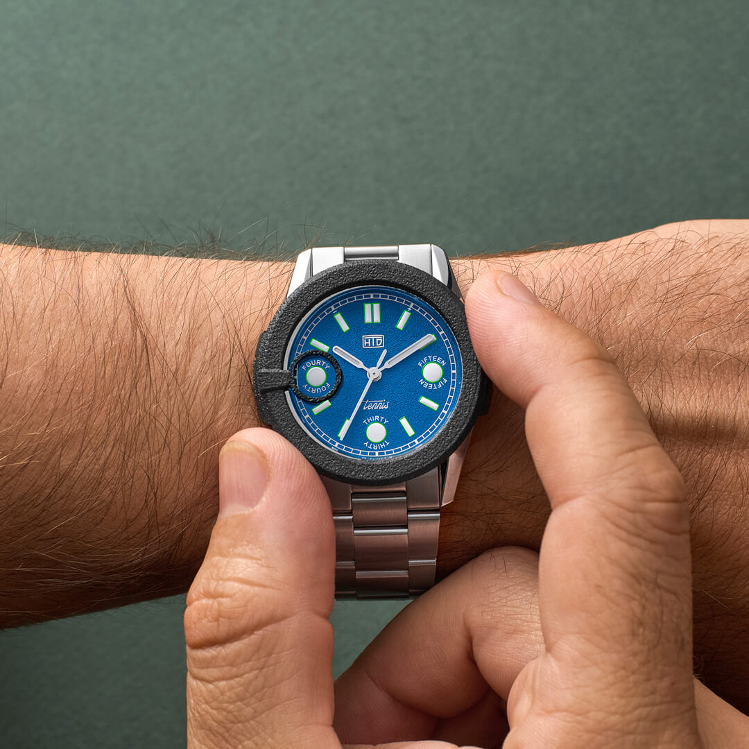 Orologio HTD Tennis Cemento al polso, quadrante blu brillante con dettagli a tema tennis, bracciale in acciaio.