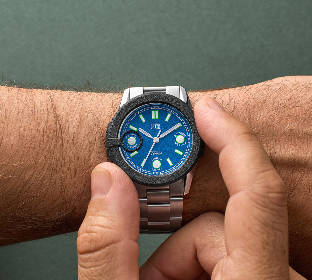 Orologio HTD Tennis Cemento al polso, quadrante blu brillante con dettagli a tema tennis, bracciale in acciaio.
