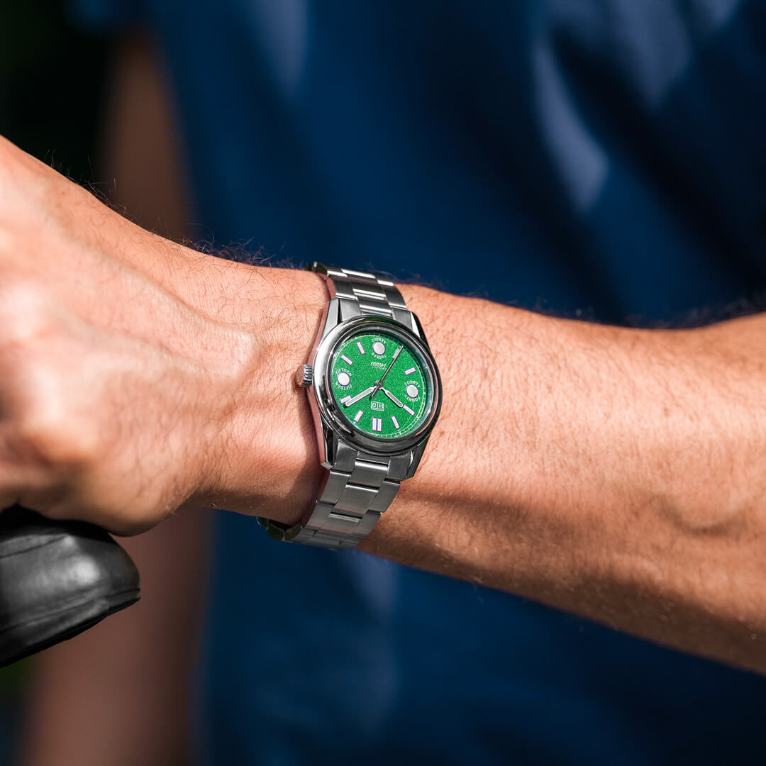 Orologio HTD Tennis Erba indossato al polso, quadrante verde acceso, bracciale in acciaio, stile sportivo.