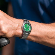 Orologio HTD Tennis Erba indossato al polso, quadrante verde acceso, bracciale in acciaio, stile sportivo.