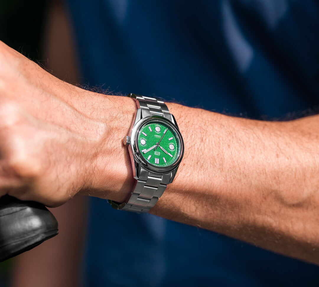 Orologio HTD Tennis Erba indossato al polso, quadrante verde acceso, bracciale in acciaio, stile sportivo.