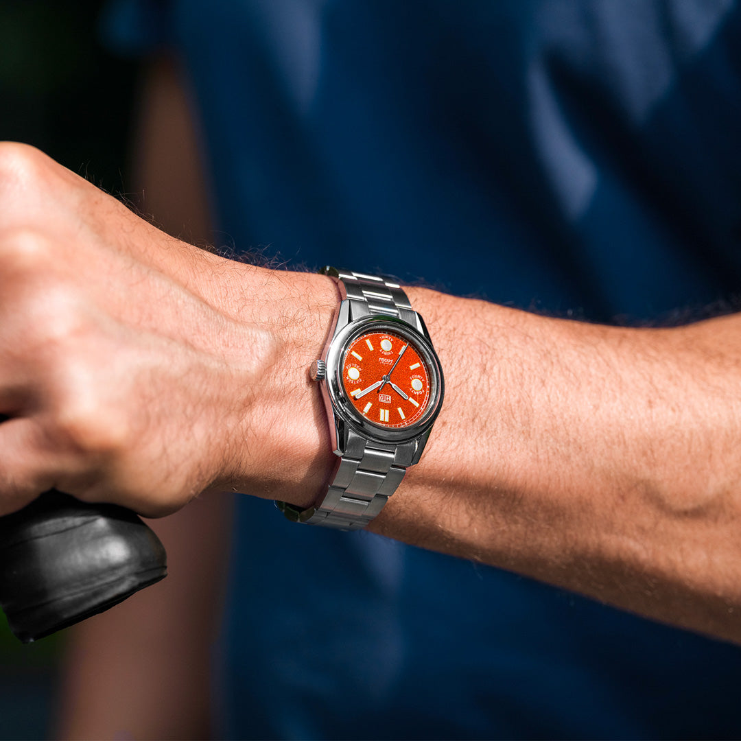 Orologio HTD Tennis Terra con quadrante arancione al polso, indossato durante l’attività sportiva all’aperto.