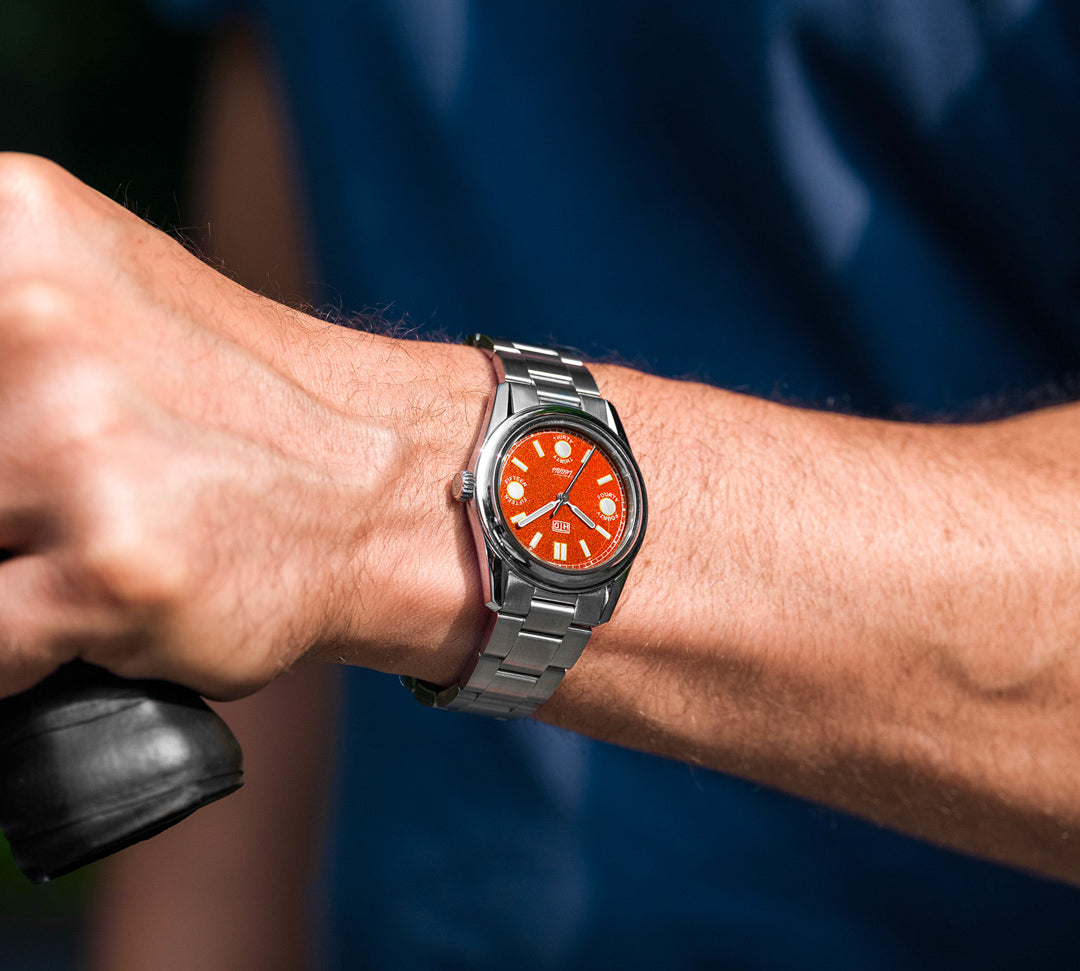 Orologio HTD Tennis Terra con quadrante arancione al polso, indossato durante l’attività sportiva all’aperto.
